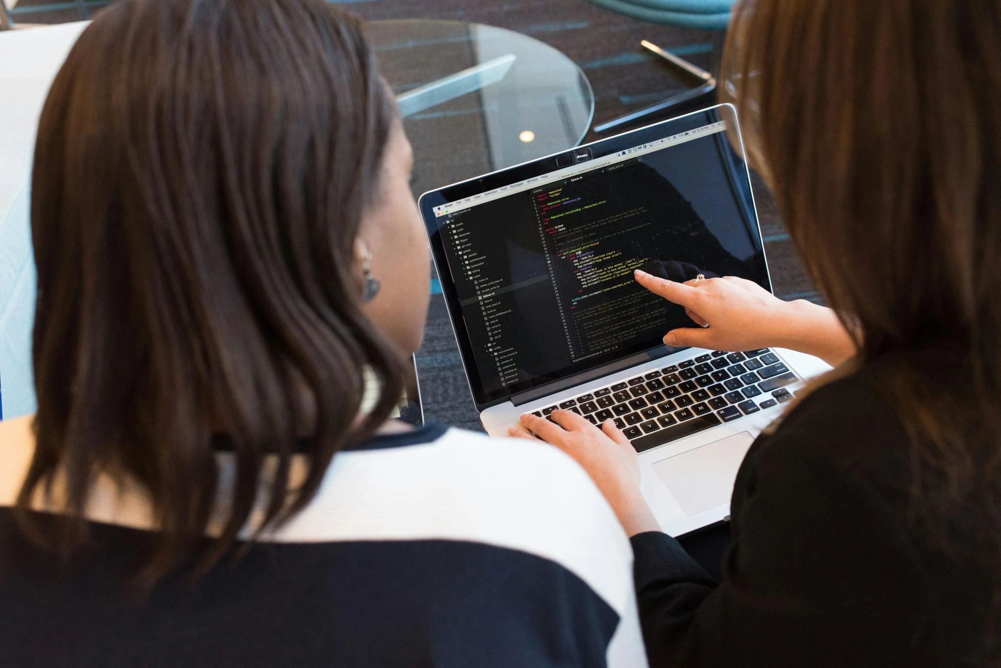 Female software engineers collaborating on code for technology recruitment placements.